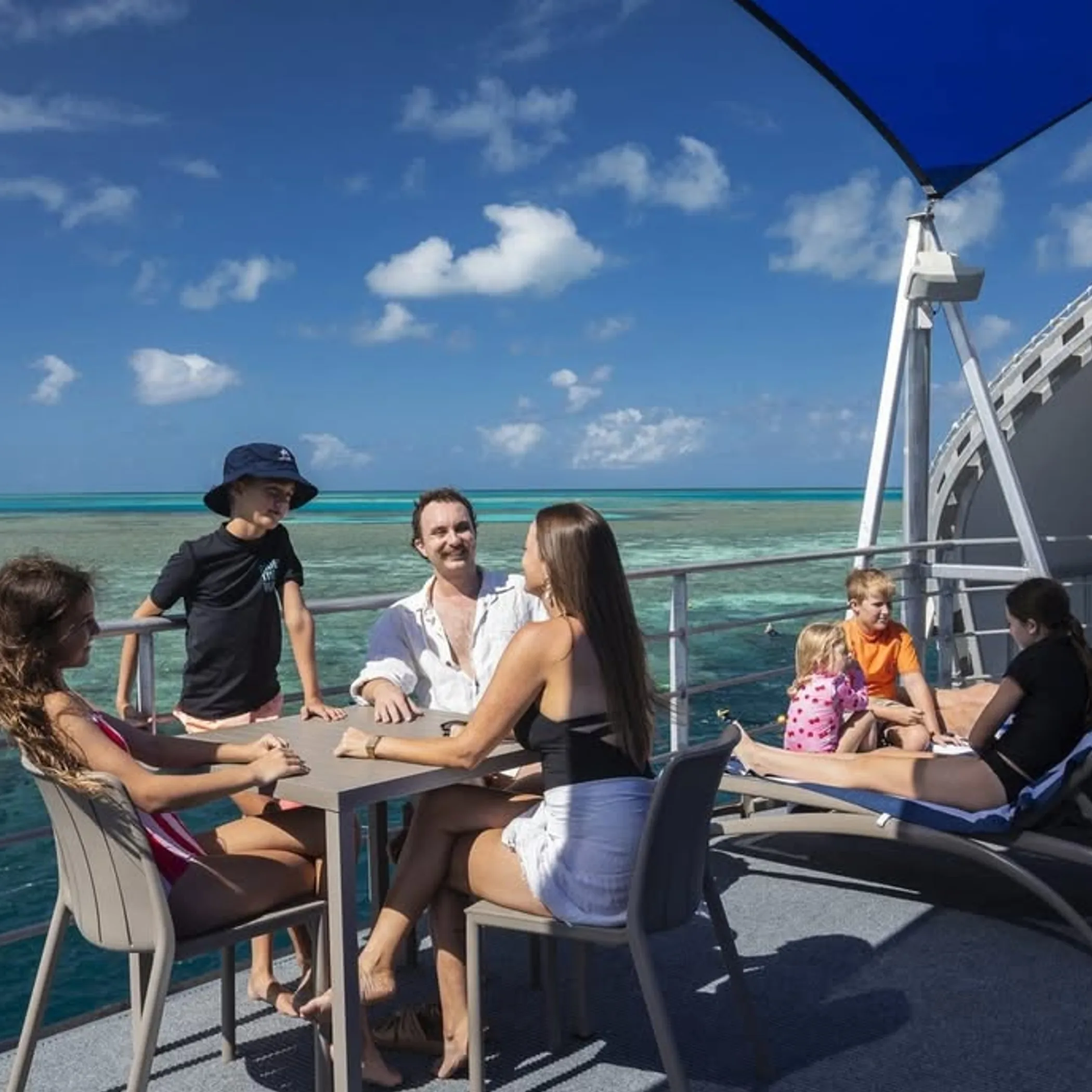 family on boat over reef
