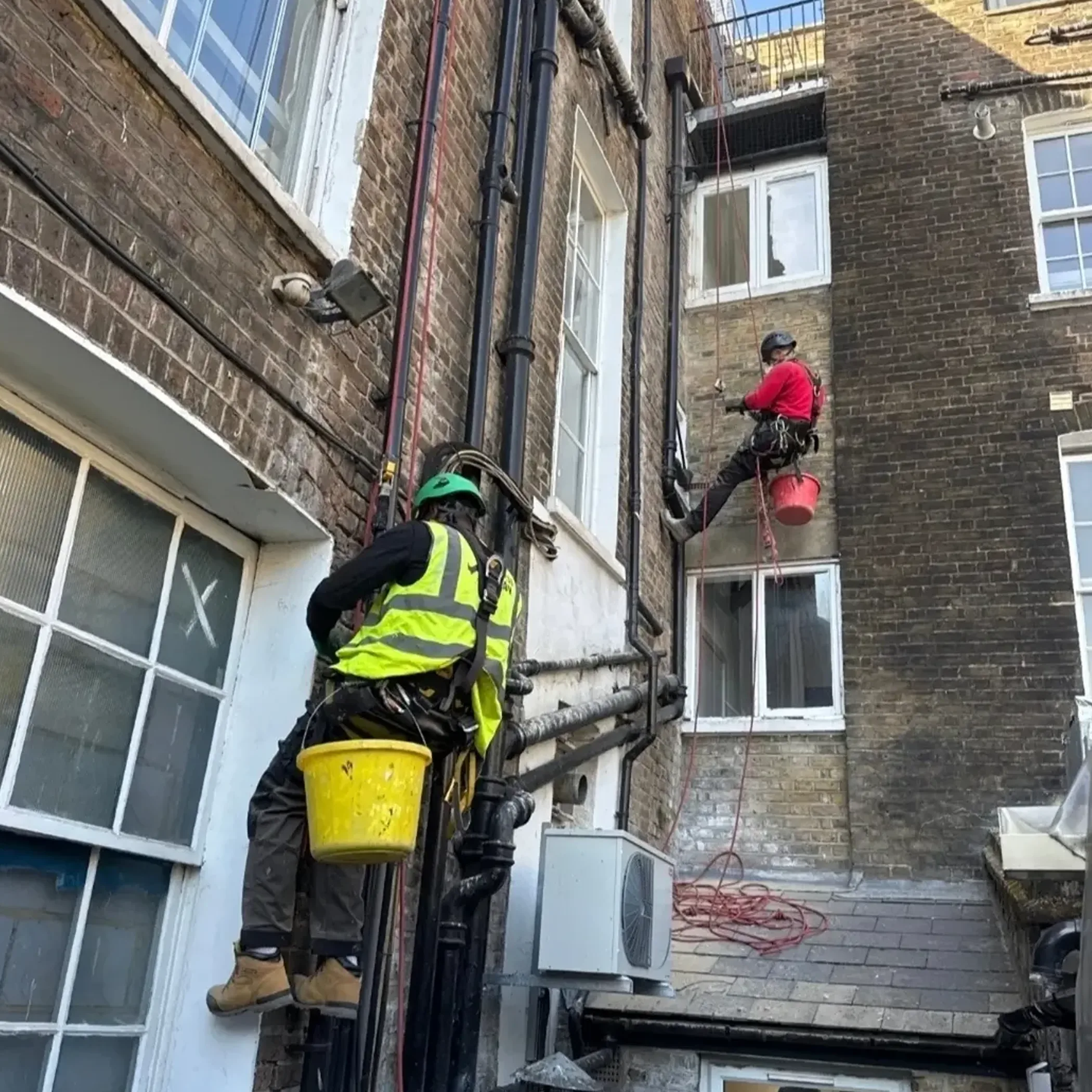 workers repointing bricks at height